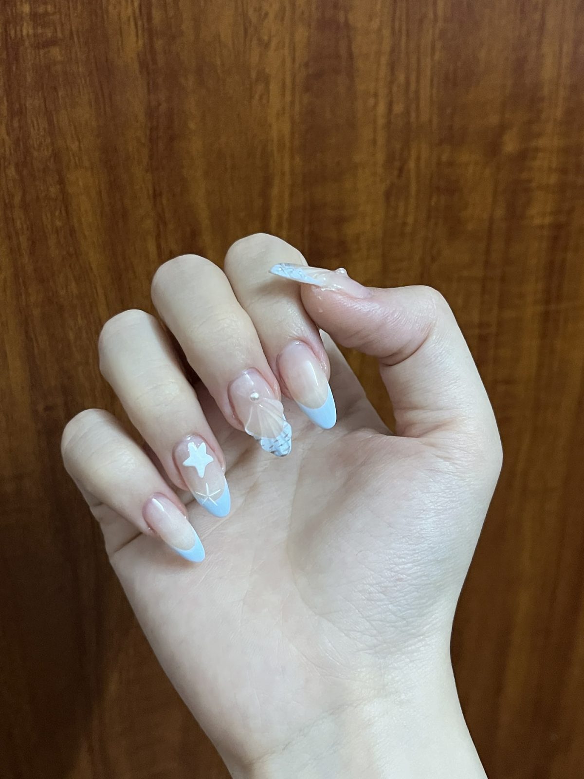 Soft blue tipped almond nails with star details